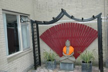 De Boeddha in de achtertuin bij het slaapkamerraam van  Veroni